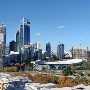 Stunning panoramic view of Perth's skyline featuring modern skyscrapers and the nearby river under a clear blue sky.