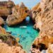 Stunning aerial view of cliffs and clear blue water at Lagos, Portugal, showcasing natural beauty.