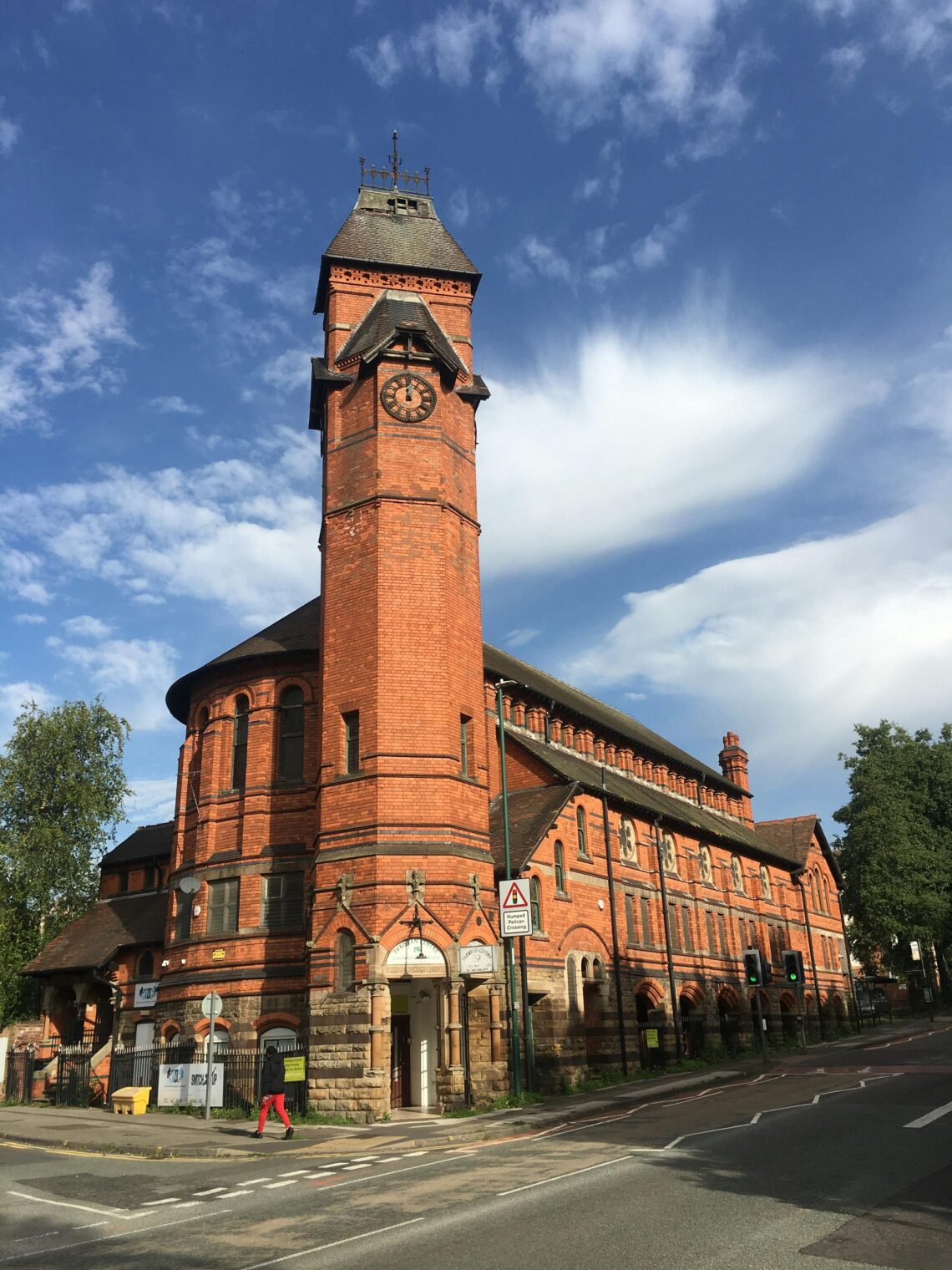 A striking red brick church and clock tower stand tall on Woodborough Road, Nottingham.