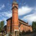A striking red brick church and clock tower stand tall on Woodborough Road, Nottingham.