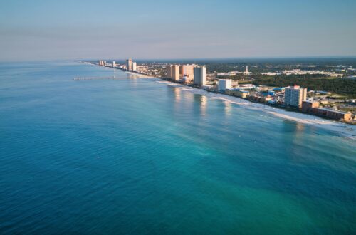 Stunning aerial view of Panama City Beach's coastline with clear blue waters and skyscrapers in view.