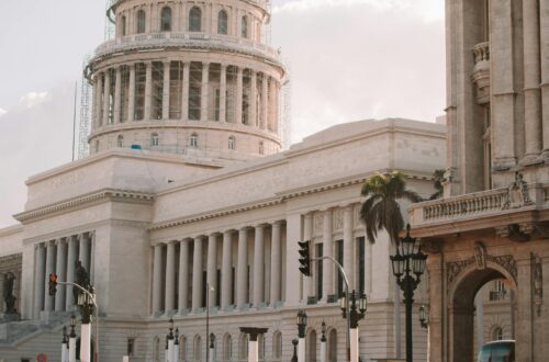 Classic cars by El Capitolio, Havana, showcasing Cuba's vintage charm and architectural beauty.