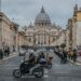 St. Peter's Basilica view with vibrant street life, Rome.