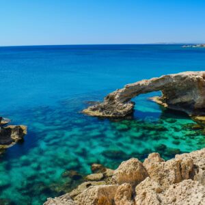 Idyllic coastal view of Cyprus arch and turquoise sea, perfect for summer travel inspiration.