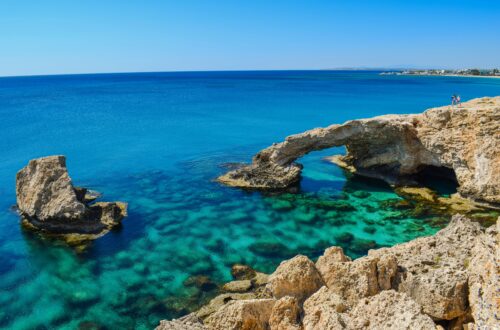 Idyllic coastal view of Cyprus arch and turquoise sea, perfect for summer travel inspiration.