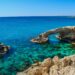 Idyllic coastal view of Cyprus arch and turquoise sea, perfect for summer travel inspiration.