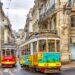 Colorful trams on a vibrant street in Lisbon, showcasing historic architecture and urban life.
