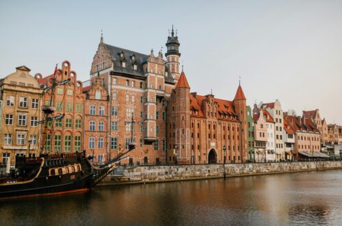 Scenic view of colorful historic buildings along the Motława River in Gdańsk, Poland.