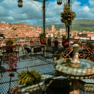 Enjoy a stunning view from a traditional Moroccan terrace overlooking Marrakesh under a vibrant sky.