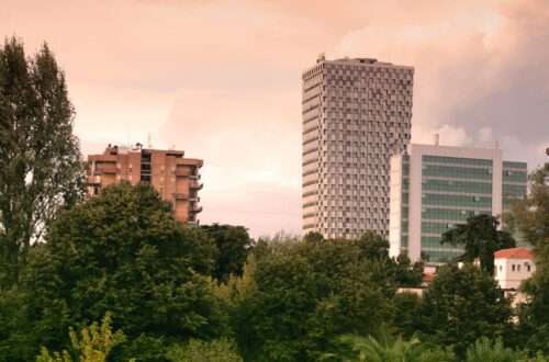 View of modern skyscrapers and lush greenery in Tirana, Albania during daylight.