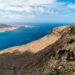A breathtaking aerial view of the rugged coastline and clear blue waters of Lanzarote, Spain.